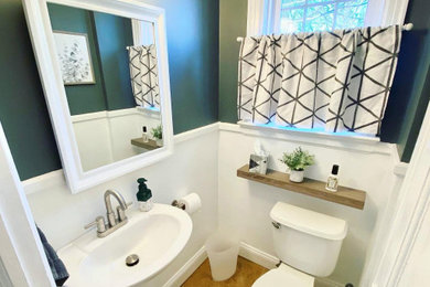 Powder room photo with white cabinets and a pedestal sink