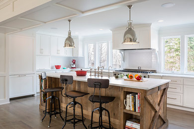 Large transitional l-shaped medium tone wood floor eat-in kitchen photo in Minneapolis with a farmhouse sink, shaker cabinets, white cabinets, marble countertops, white backsplash, ceramic backsplash, paneled appliances and an island