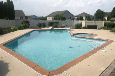 Elegant backyard stamped concrete and l-shaped natural pool photo in Philadelphia