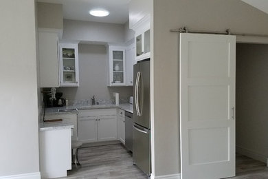 Example of a transitional porcelain tile and gray floor kitchen design in Sacramento with an undermount sink, shaker cabinets, white cabinets, quartzite countertops and stainless steel appliances