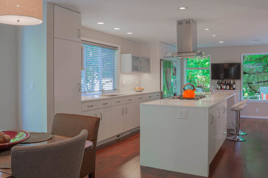 Inspiration for a mid-sized contemporary single-wall medium tone wood floor eat-in kitchen remodel in Seattle with an undermount sink, flat-panel cabinets, white cabinets, laminate countertops, white backsplash and an island