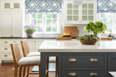 Large transitional dark wood floor and brown floor kitchen photo in Boston with a single-bowl sink, shaker cabinets, white cabinets, soapstone countertops, white backsplash, marble backsplash, stainless steel appliances, an island and black countertops