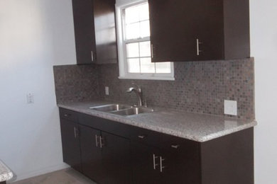 Kitchen - small contemporary galley ceramic tile and beige floor kitchen idea in Los Angeles with a double-bowl sink, flat-panel cabinets, dark wood cabinets, granite countertops, gray backsplash and mosaic tile backsplash