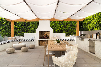 Example of a large trendy backyard concrete paver patio design in Phoenix with an awning and a bbq area