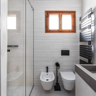 Idee per una piccola stanza da bagno minimal con ante a filo, ante grigie, WC sospeso, piastrelle beige, piastrelle in ceramica, pareti beige, pavimento in gres porcellanato, lavabo integrato, top piastrellato, pavimento beige, top grigio e mobile bagno sospeso