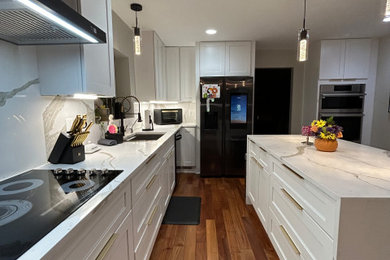 Kitchen - large craftsman medium tone wood floor, orange floor and coffered ceiling kitchen idea in DC Metro with an undermount sink, shaker cabinets, white cabinets, quartz countertops, white backsplash, quartz backsplash, black appliances and white countertops