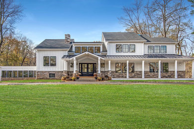 Large cottage white two-story concrete fiberboard exterior home photo in New York with a mixed material roof