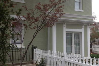 Inspiration for a mid-sized timeless green two-story brick flat roof remodel in DC Metro