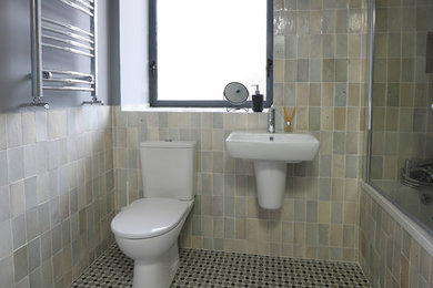 This is an example of a country kids bathroom in Dublin with a drop-in tub, a shower/bathtub combo, white tile, cement tile, cement tiles and grey floor.