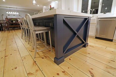 Inspiration for a large transitional l-shaped light wood floor and yellow floor eat-in kitchen remodel in Boston with a farmhouse sink, beaded inset cabinets, white cabinets, quartz countertops, white backsplash, porcelain backsplash, stainless steel appliances, an island and white countertops