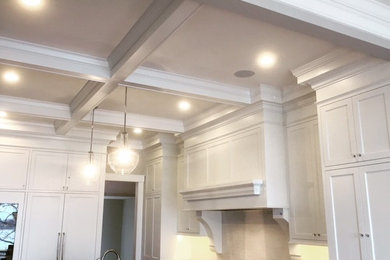 Inspiration for a large timeless u-shaped enclosed kitchen remodel in Minneapolis with beige backsplash, stainless steel appliances, shaker cabinets, white cabinets and an island