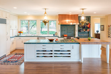 Example of a large classic l-shaped medium tone wood floor eat-in kitchen design in Minneapolis with an undermount sink, shaker cabinets, white cabinets, tile countertops, blue backsplash, paneled appliances, an island, ceramic backsplash and turquoise countertops