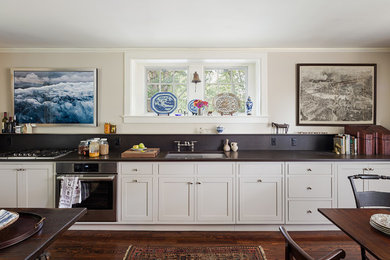 Inspiration for a mid-sized transitional single-wall medium tone wood floor and brown floor eat-in kitchen remodel in Philadelphia with an undermount sink, shaker cabinets, green cabinets, brown backsplash, stainless steel appliances, no island and soapstone countertops