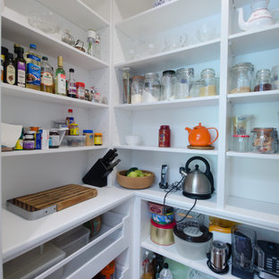Exemple d'une grande arrière-cuisine chic en L avec un évier encastré, un placard à porte shaker, des portes de placard blanches, un plan de travail en quartz modifié, une crédence beige, une crédence en dalle métallique, un électroménager en acier inoxydable, un sol en bois brun et un îlot central.