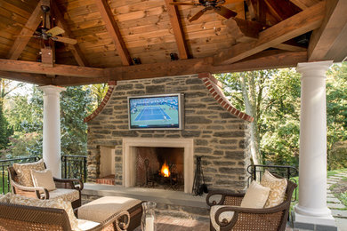 Example of a classic patio design in Philadelphia with a fire pit and a gazebo