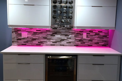 Inspiration for a small modern home bar remodel in Calgary with white cabinets, quartz countertops, gray backsplash and glass tile backsplash