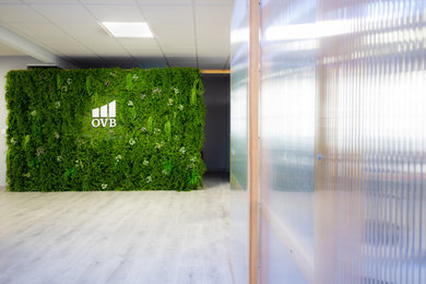 Imagen de despacho minimalista grande sin chimenea con paredes verdes, suelo laminado, suelo gris y panelado
