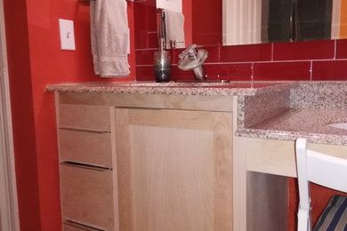 This is an example of a contemporary bathroom with shaker cabinets, light wood cabinets, red tile, glass tile, an undermount sink, granite benchtops and brown benchtops.