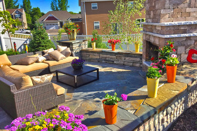 Example of a mid-sized classic backyard stone patio design in Minneapolis with a fire pit and no cover