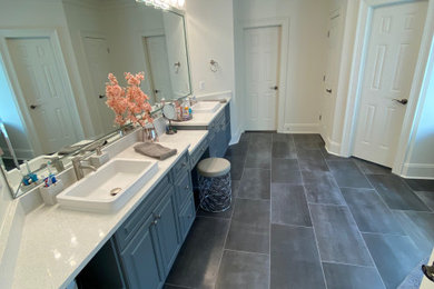 Example of a large classic master porcelain tile, gray floor, double-sink and tray ceiling toilet room design in Atlanta with raised-panel cabinets, gray cabinets, quartz countertops, white countertops and a built-in vanity