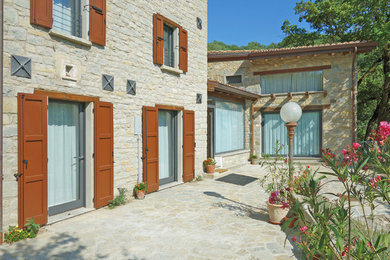 Idee per un giardino country esposto in pieno sole in cortile in estate con pavimentazioni in pietra naturale