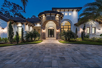 Photo of a large mediterranean front door in Miami with white walls, travertine floors, a double front door and a metal front door.