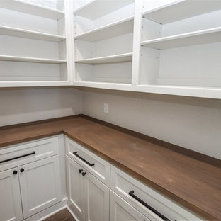 Mid-sized transitional kitchen pantry photos - Example of a mid-sized transitional kitchen pantry design in New Orleans with shaker cabinets, white cabinets, wood countertops and brown countertops
