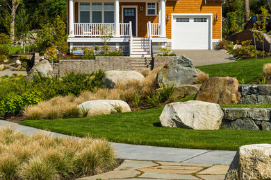 Large beach style front yard garden in Seattle with a retaining wall and natural stone pavers.