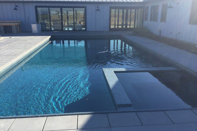 Example of a mid-sized transitional backyard tile and rectangular lap hot tub design in Orange County