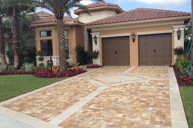 Example of a large tuscan two-story stucco exterior home design in Miami with a clipped gable roof