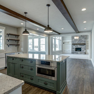 Mid-sized craftsman kitchen pantry inspiration - Kitchen pantry - mid-sized craftsman u-shaped medium tone wood floor and brown floor kitchen pantry idea in Grand Rapids with a farmhouse sink, shaker cabinets, white cabinets, granite countertops, white backsplash, ceramic backsplash, stainless steel appliances and an island