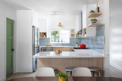 Inspiration for a small 1960s terrazzo floor kitchen remodel in San Diego with an undermount sink, flat-panel cabinets, quartz countertops, blue backsplash, ceramic backsplash, stainless steel appliances and white countertops