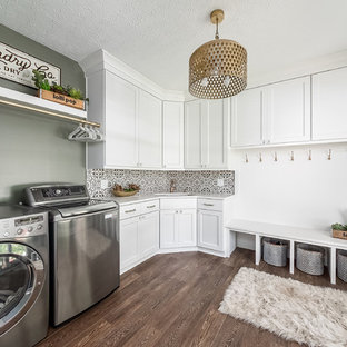 コロンバスのトランジショナルスタイルのおしゃれな家事室 (アンダーカウンターシンク、シェーカースタイル扉のキャビネット、白いキャビネット、緑の壁、濃色無垢フローリング、左右配置の洗濯機・乾燥機、茶色い床、白いキッチンカウンター) の写真