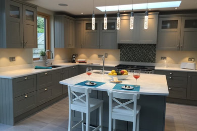 Eat-in kitchen - mid-sized transitional l-shaped porcelain tile and gray floor eat-in kitchen idea in Dublin with an undermount sink, shaker cabinets, gray cabinets, quartz countertops, multicolored backsplash, mosaic tile backsplash, stainless steel appliances and an island