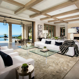Mediterranean open plan living room in Orange County with beige walls and a wall mounted tv.