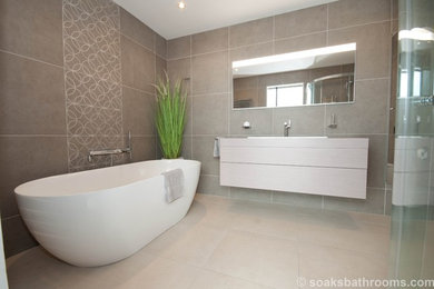 This is an example of a medium sized contemporary family bathroom with flat-panel cabinets, light wood cabinets, a freestanding bath, a corner shower, a wall mounted toilet, beige tiles, porcelain tiles, brown walls, porcelain flooring, a console sink and wooden worktops.