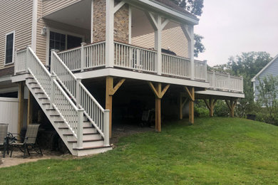Example of a large backyard outdoor kitchen deck design in Boston with a roof extension