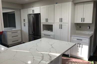 Eat-in kitchen - mid-sized contemporary u-shaped vinyl floor and gray floor eat-in kitchen idea in Denver with an undermount sink, shaker cabinets, white cabinets, quartz countertops, white backsplash, quartz backsplash, stainless steel appliances, an island and white countertops