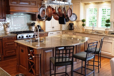 Open concept kitchen - large traditional u-shaped medium tone wood floor open concept kitchen idea in Vancouver with a double-bowl sink, raised-panel cabinets, medium tone wood cabinets, granite countertops, green backsplash, ceramic backsplash, stainless steel appliances and an island