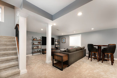 Basement - mid-sized industrial look-out carpeted and beige floor basement idea in Chicago with gray walls