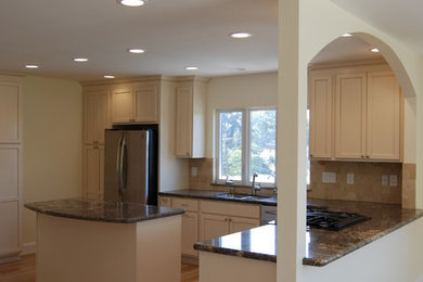 Inspiration for a mid-sized transitional light wood floor eat-in kitchen remodel in San Diego with an undermount sink, shaker cabinets, white cabinets, granite countertops, beige backsplash and stainless steel appliances