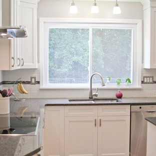 Traditional kitchen pantry designs - Inspiration for a timeless l-shaped light wood floor and brown floor kitchen pantry remodel in St Louis with a drop-in sink, recessed-panel cabinets, white cabinets, quartz countertops, white backsplash, subway tile backsplash, stainless steel appliances and an island