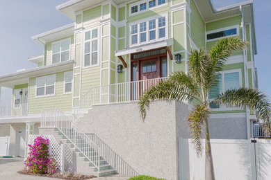 Mid-sized coastal green three-story wood and clapboard exterior home idea in Tampa with a shingle roof