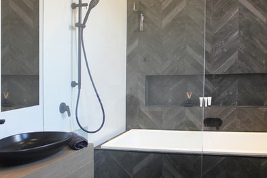 Small contemporary wet room bathroom in Sydney with flat-panel cabinets, medium wood cabinets, a drop-in tub, a wall-mount toilet, multi-coloured tile, porcelain tile, multi-coloured walls, porcelain floors, a vessel sink, laminate benchtops, multi-coloured floor and an open shower.
