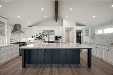 Large modern u-shaped open plan kitchen in San Francisco with a submerged sink, shaker cabinets, white cabinets, engineered stone countertops, blue splashback, glass tiled splashback, stainless steel appliances, vinyl flooring, an island, brown floors, white worktops and a vaulted ceiling.