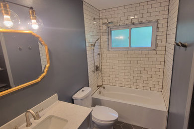Large elegant master white tile and subway tile porcelain tile, blue floor and single-sink bathroom photo in Cincinnati with shaker cabinets, blue cabinets, a one-piece toilet, blue walls, a wall-mount sink, granite countertops, white countertops and a built-in vanity