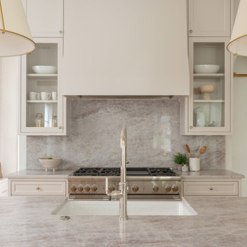 Kitchen range wall with full-height stone slab backsplash and custom