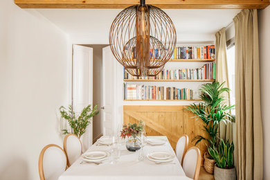 Inspiration for a mediterranean dining room in Barcelona with white walls and light hardwood floors.
