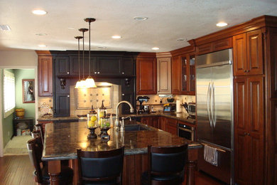 Inspiration for a large contemporary l-shaped dark wood floor and brown floor enclosed kitchen remodel in Orange County with an undermount sink, raised-panel cabinets, dark wood cabinets, granite countertops, beige backsplash, ceramic backsplash, stainless steel appliances and an island