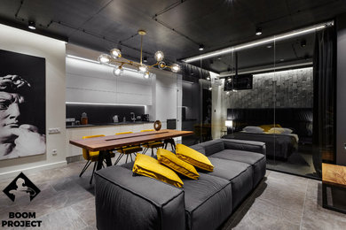 Ejemplo de salón tipo loft urbano de tamaño medio con paredes negras, suelo de baldosas de cerámica, televisor colgado en la pared y suelo gris